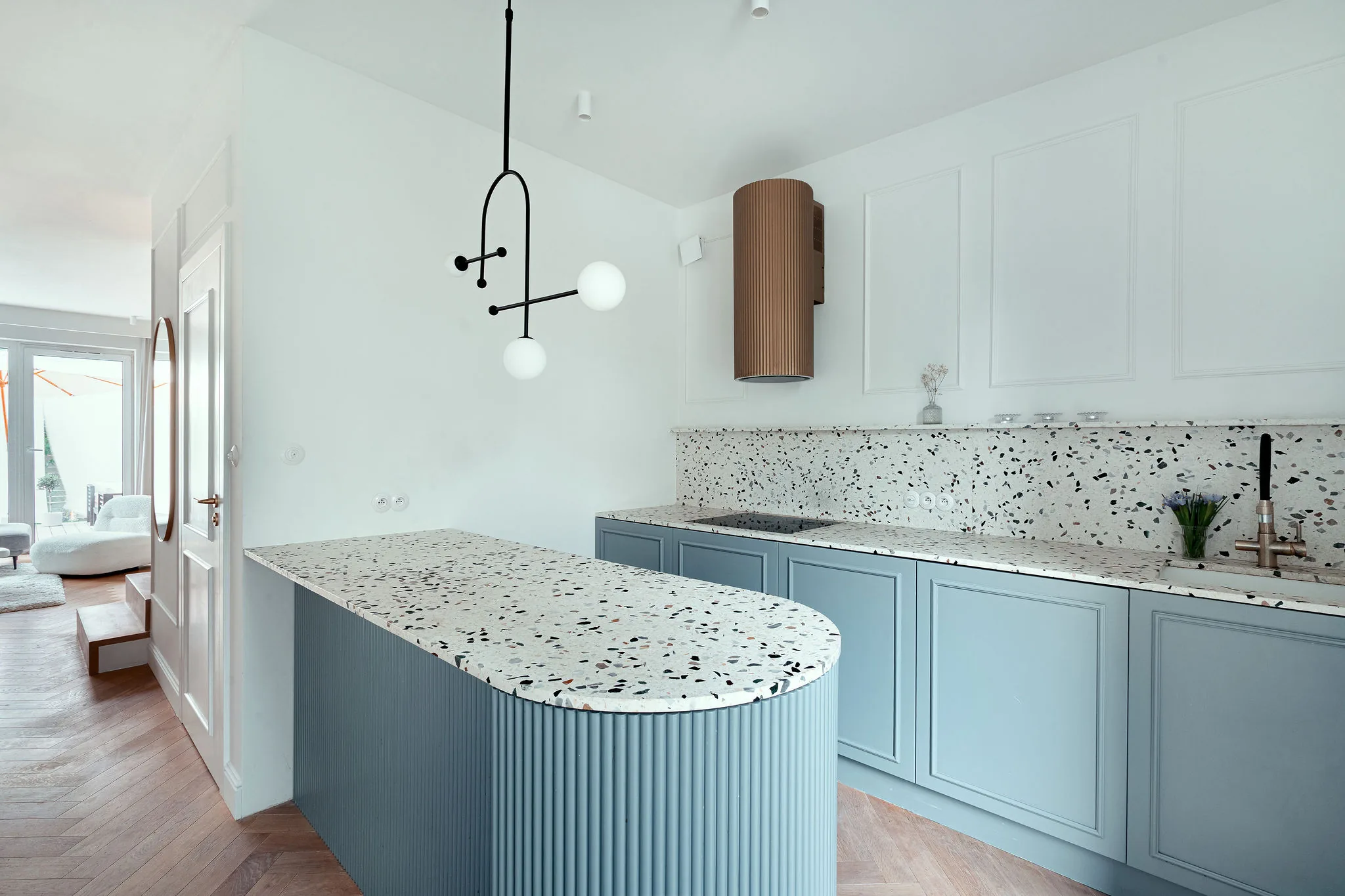 Kuchnia z blatem z terrazzo i błękitną zabudową, zaprojektowana przez KMN Studio